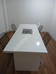 Glossy white table set with chairs