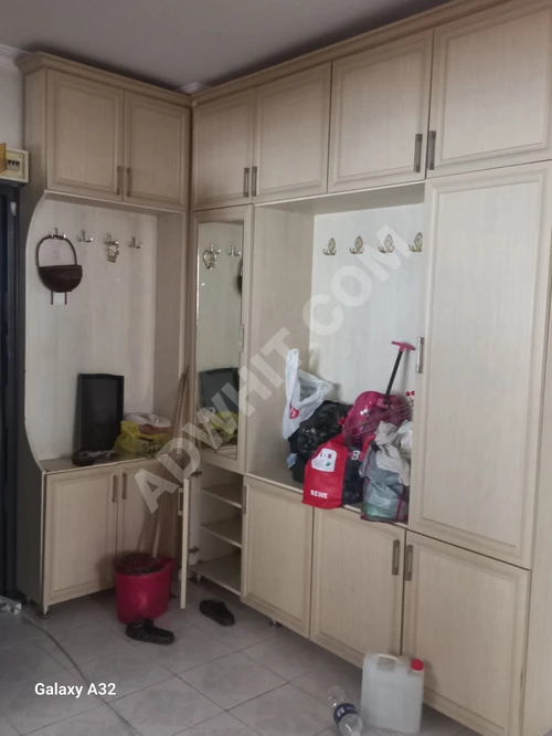 Büyük bir antre dolabı (misafir için) ayakkabılık ve giysi askısı.