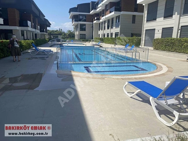 1+1 apartment with an area of 50m² on the ground floor with a swimming pool and a closed parking space in Lara Loft complex.