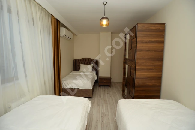 Room within a shared apartment of three rooms, a living room, two bathrooms, and a kitchen for monthly rent.