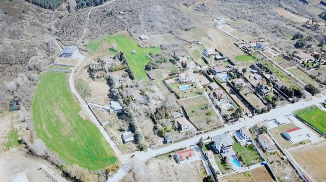 قطعة أرض للإيجار على الشارع الرئيسي، بها كهرباء وماء متصلان.